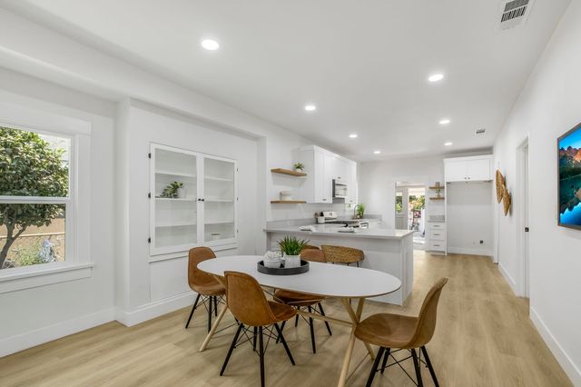 Dining area with a round table and a galley kitchen beyond