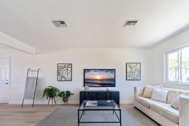 Living room with a sofa, a glass coffee table and a window