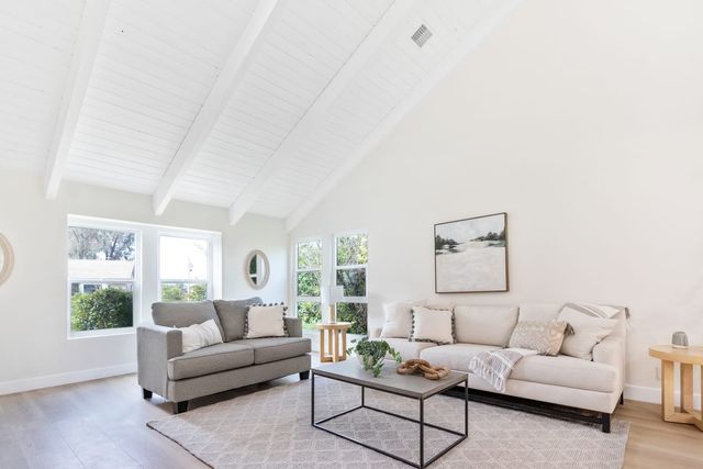 Vaulted living room with two sofas and windows on two walls