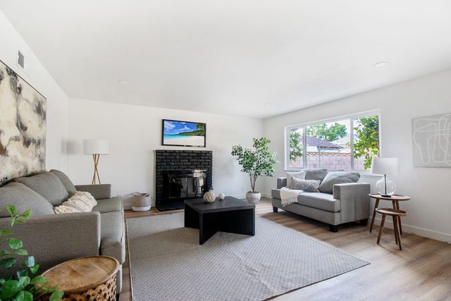 Living room with a black brick fireplace and two gray sofas around a low table