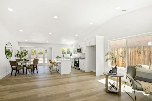 Open dining area and white kitchen with French doors and a sliding door